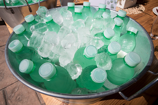 Small water bottles cooling in a zinc washbowl. Overhead view