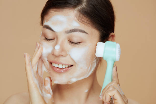 istock young woman with massager washing face 1696872498