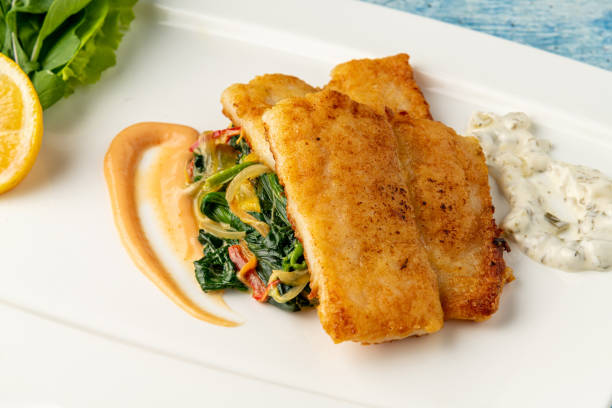 istock Fried Panga Fillet with greens and onions on the side and spinach underneath 1696873620