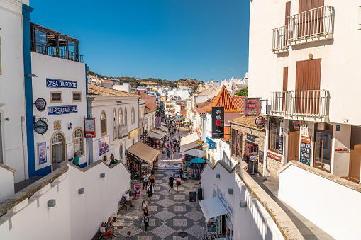 Albufeira, ALGARVE, Portugal - September 28 2022: Beautiful city center of the city. Old town with white houses and narrow pedestrian streets. Travel destination in South of Portugal. People on street