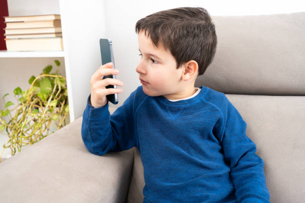 istock boy with eyestrain watching the smartphone 1696907461