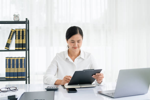 istock asian business woman working with paper document. 1696911386