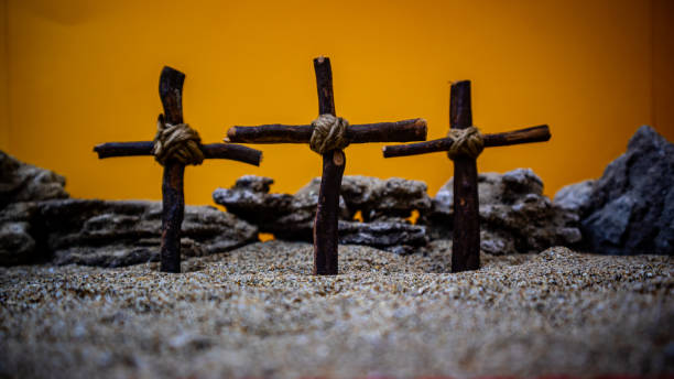 istock crosses stuck in the sand on an orange background 1696915869