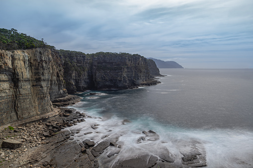 Impressive high cliff Waterfall Track located near Eaglehawk Neck, Tasmania, Australia