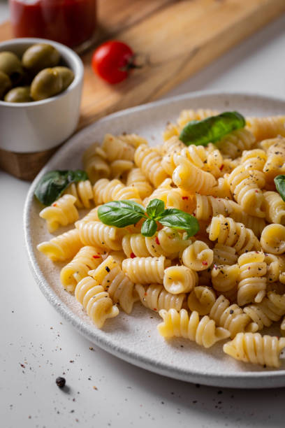 istock Dinner with italian pasta with basil and tomatoes 1696924403