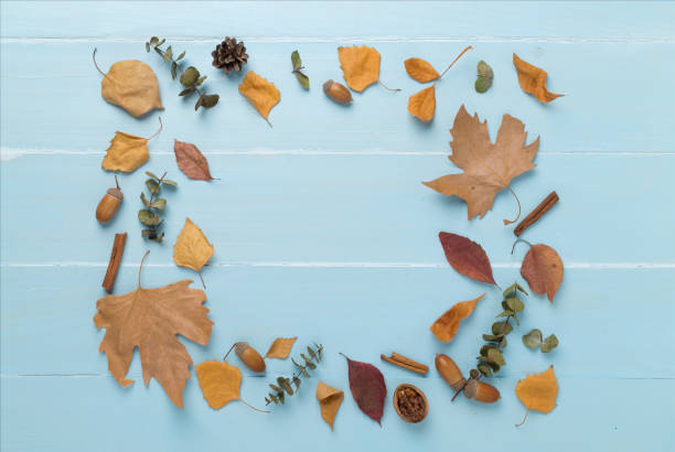 istock Autumn leaves with decor on wooden background, top view 1696942903