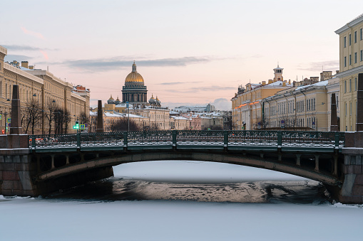 View of St. Isaac's Cathedral and the Moika River embankment against the background of the Kissing Bridge on a winter morning, St. Petersburg, Russia