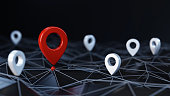 Red unique map pin / location pin icon surrounded other small ones on the abstract geometric low polygonal surface with plexus effect