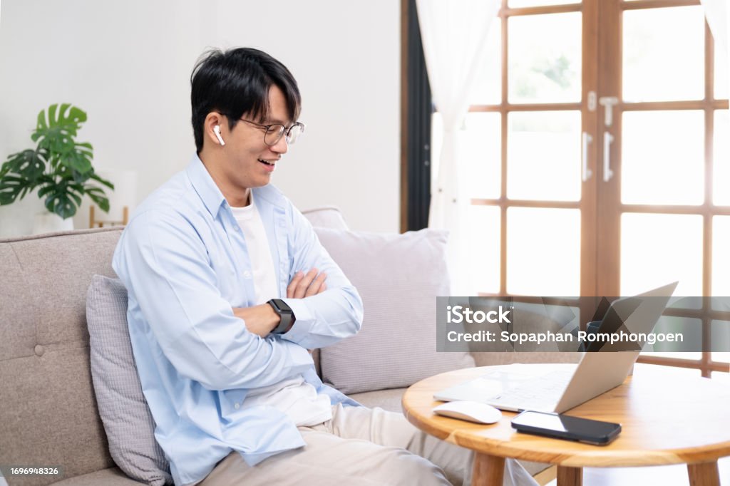Young Male Tech User Relaxing On Sofa Watching Laptop Computer Man ...