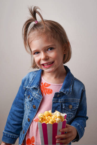 istock The 3 years old girl with sweet popcorn. 1696982002