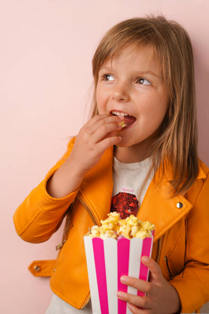 istock Little girl eating sweet popcorn 1696983721