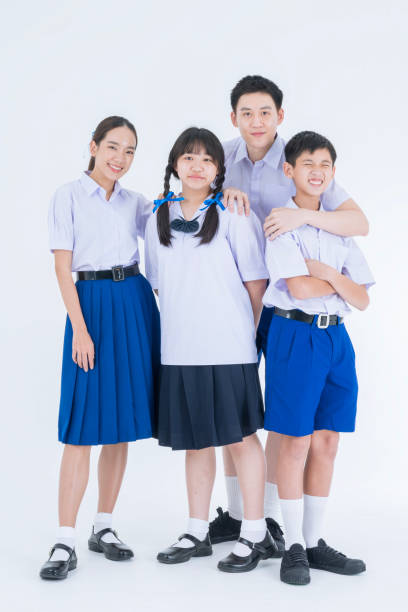istock Thai students. Group students standing together in the studio. Asian girl and boy in student uniform on white background. 1696990255