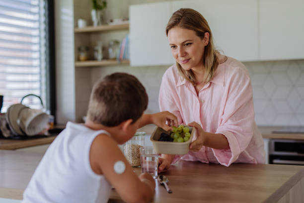 継続的なグルコースモニターを持つ糖尿病の少年は、食事に注意を払っています。 - hypoglycemia diabetes child hyperglycemia ストックフォトと画像