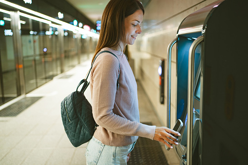 Young woman buying train tickets at the train station