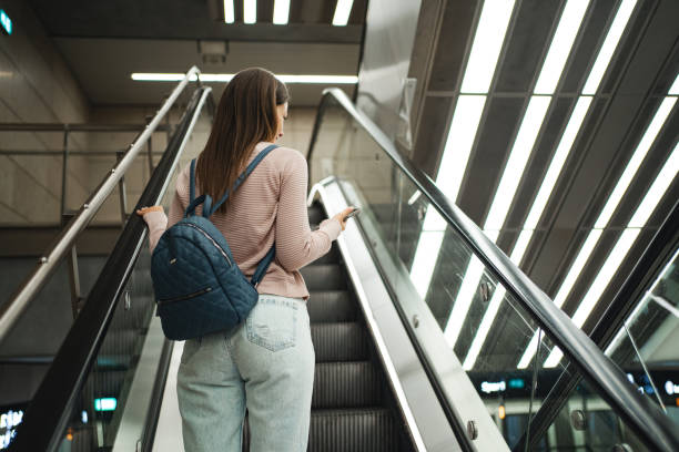 istock Young woman looking at her mobile phone at the train station 1697013682