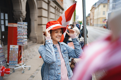 Female tourist standing by the street shop, buying local souvenirs in the city of Copenhagen, Denmark