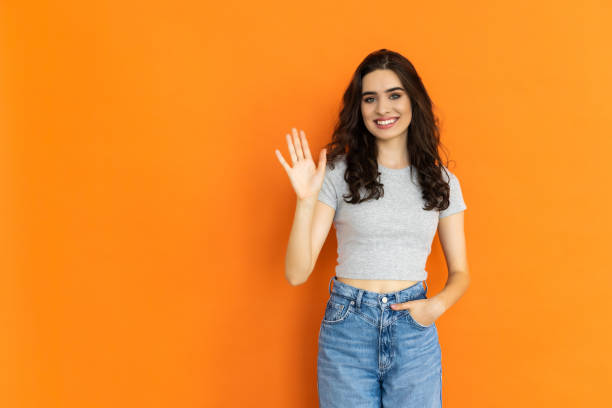 istock Happy young woman giving high five on orange background, space for text 1697032905