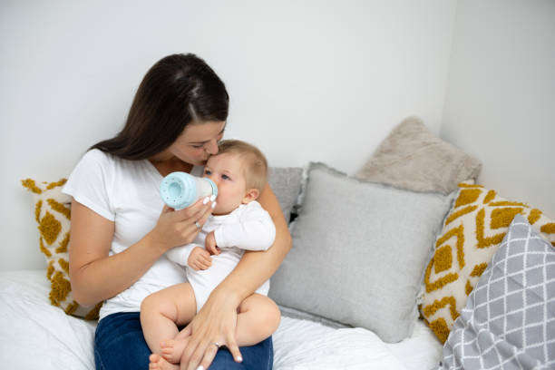 istock pretty young mother feeding her baby with bottle 1697042857