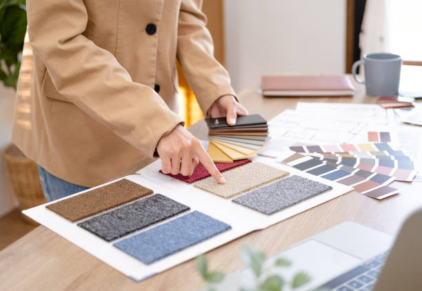istock Young asian female interior designer or architect working on creative project with drawing, material sample & laptop computer in office. Business of Real estate, home decoration & renovation concept. 1697059608