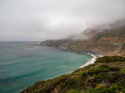 Big Sur California coast, bridge, beach, rocks, clouds, and surfing waves