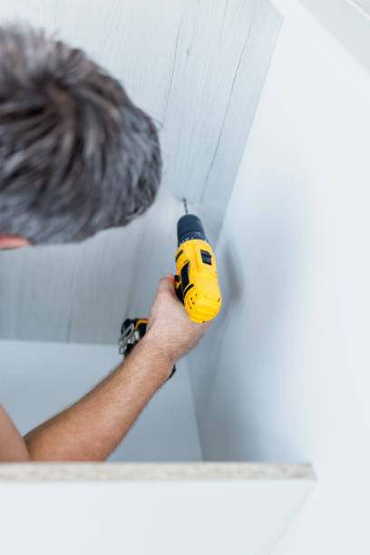 istock Close up of man holding electrical battery screwdriver while installing wooden kitchen shelves 1697110098