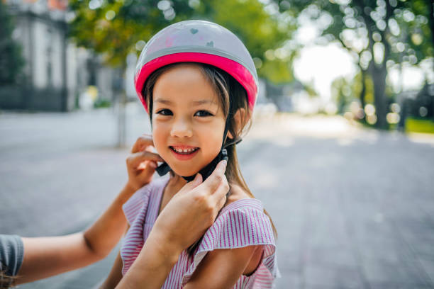 istock Mother helping her daughter to put a helmet 1697112887