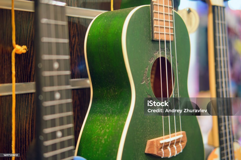 Green ukulele in a music shop, small green guitar Acoustic Guitar Stock Photo