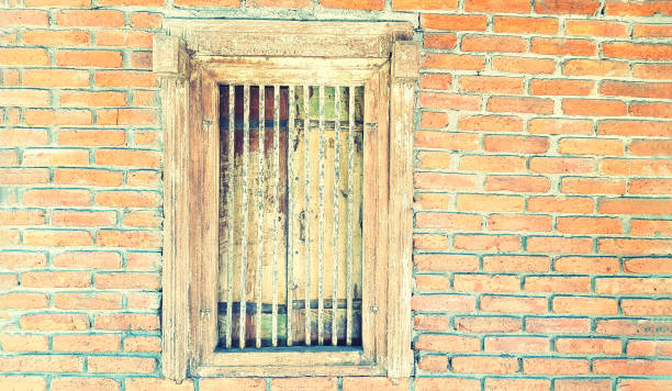 istock Retro wooden window with rusty chrome on brick wall with copy space on right in vintage tone. The exterior design part of home or house and Decorated place concept. 1697138080