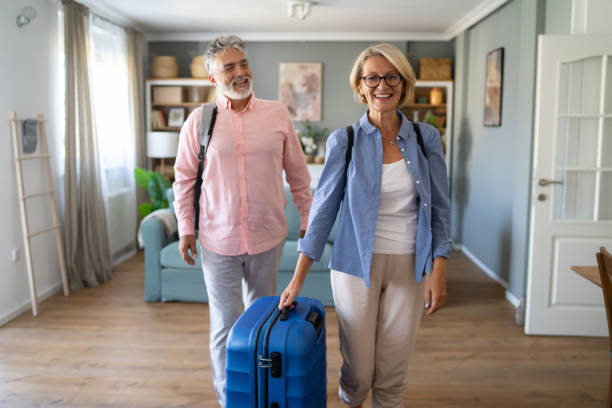 Senior Couple Standing With Suitcase About To Leave For Vacation