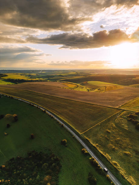 vista aerea del drone della strada che attraversa il bellissimo paesaggio di south downs nel sud-est dell'inghilterra all'ora d'oro - southeast england foto e immagini stock