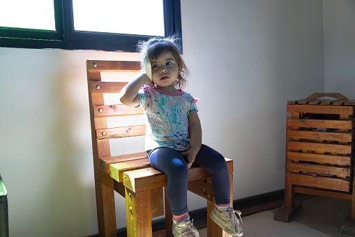 little girl on a chair in room
