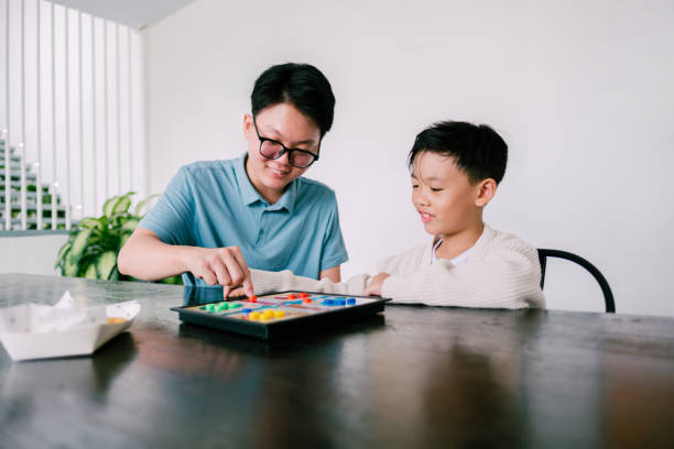 istock Happy Asian siblings playing board game together. 1697147672