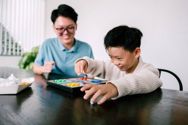 istock Happy Asian siblings playing board game together. 1697147673