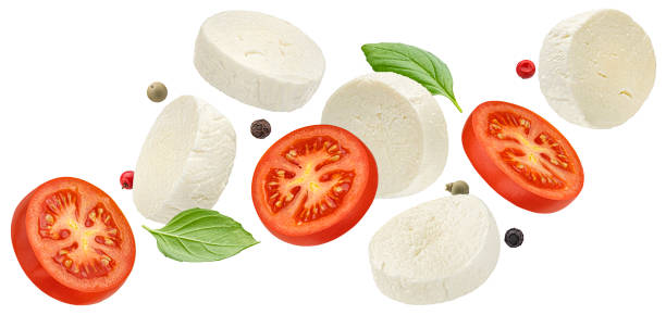 istock Falling mozzarella cheese and tomato slices with basil leaves isolated on white background 1697147956