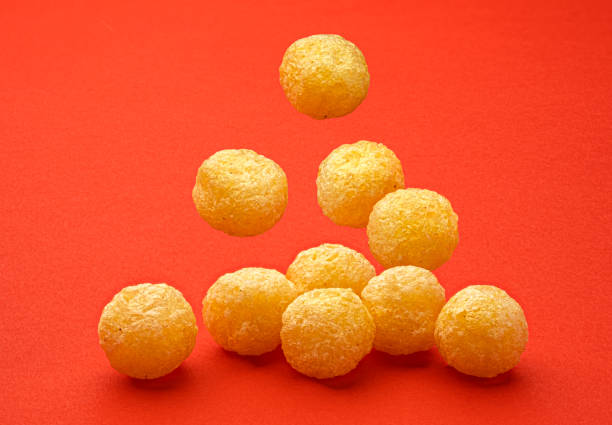 istock Falling corn balls isolated on red background, full depth of field 1697149109
