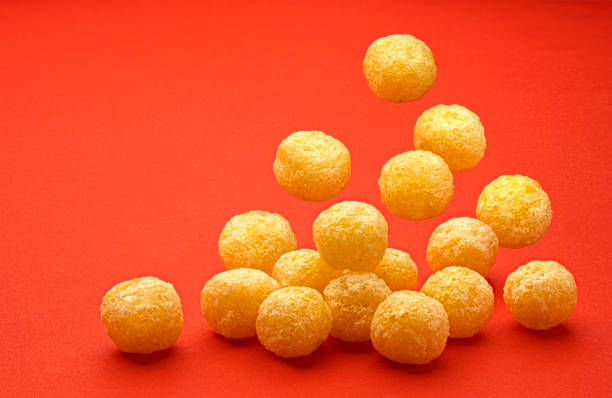 Falling corn balls isolated on red background, full depth of field