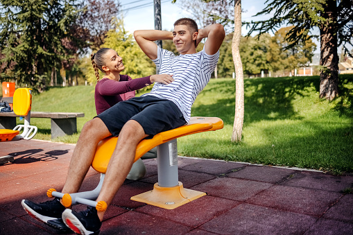 Young couple living healthy lifestyle with exercising at open gym