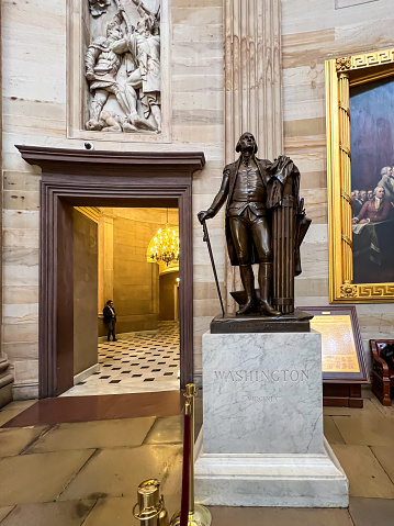 Washington, DC - September 20, 2023: Bronze statue of George Washington on a pedestal in Statuary Hall in the Capitol Rotunda in Washington DC. The bronze statue was sculpted by Jean Antoine Houdin and given to the National Statuary Hall Collection by Virginia in 1934.