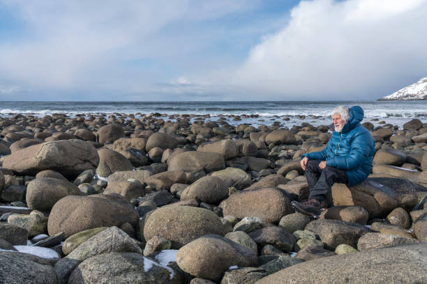 istock Man at Unstad beach, Lofoten islands, Norway in winter 1697189493