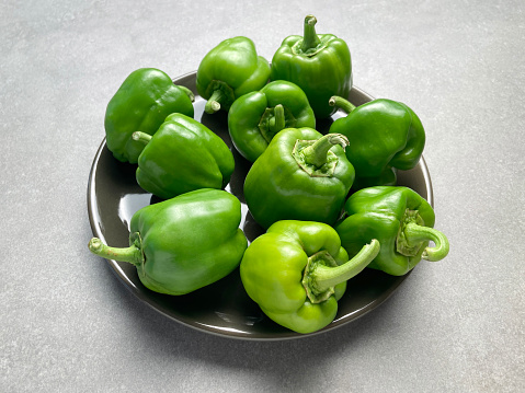 Fresh green bell peppers in a plate with copy space