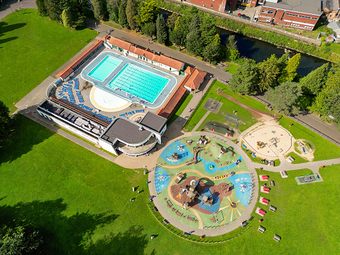 Pontypridd, Wales - 12 September 2023: Drone view of the open air lido swimming pool and children's playground in the town's Ynysangharad park.