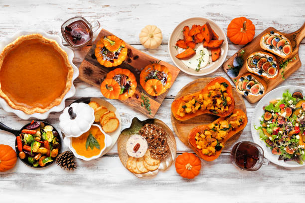 Delicious autumn meal table scene. Top down view on a white wood background.