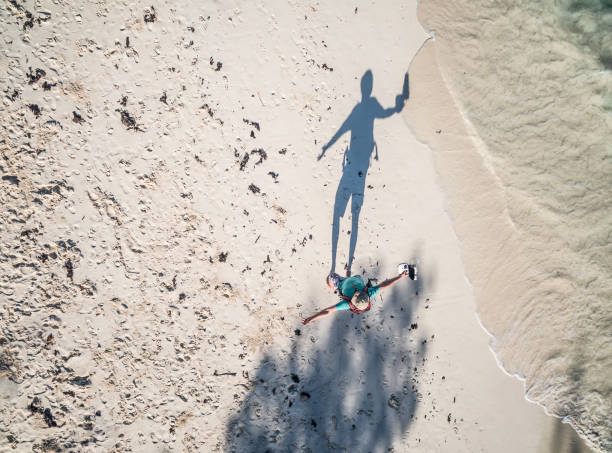 istock walking man in hat with hands aside on african beach, top view 1697247567