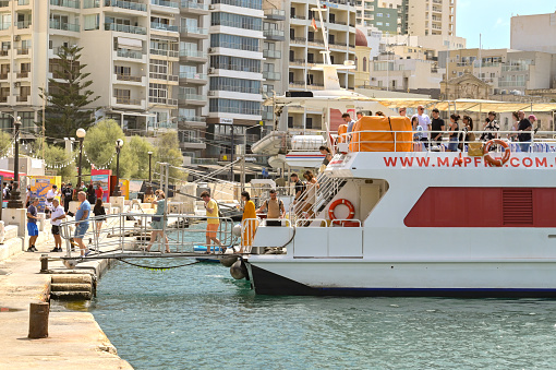 Sliema, Malta - 6 August 2023: Passengers getting off a small ferry in Sliema after arriving from the island's capital, Valletta.