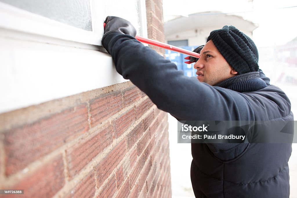 Burglar prying window open with crowbar  25-29 Years Stock Photo