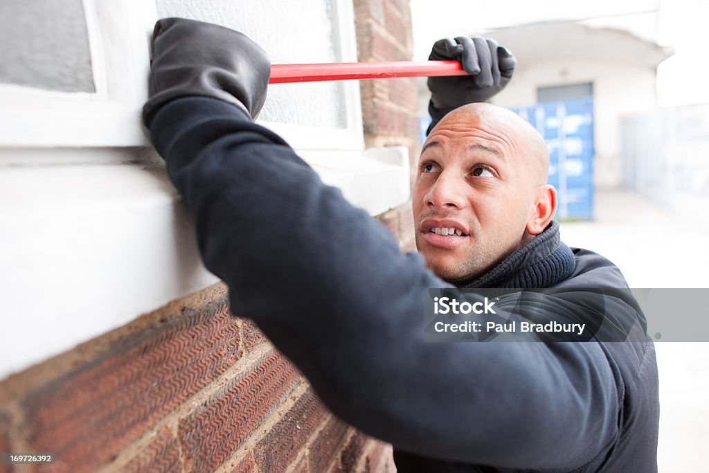 Burglar prying window open with crowbar  25-29 Years Stock Photo