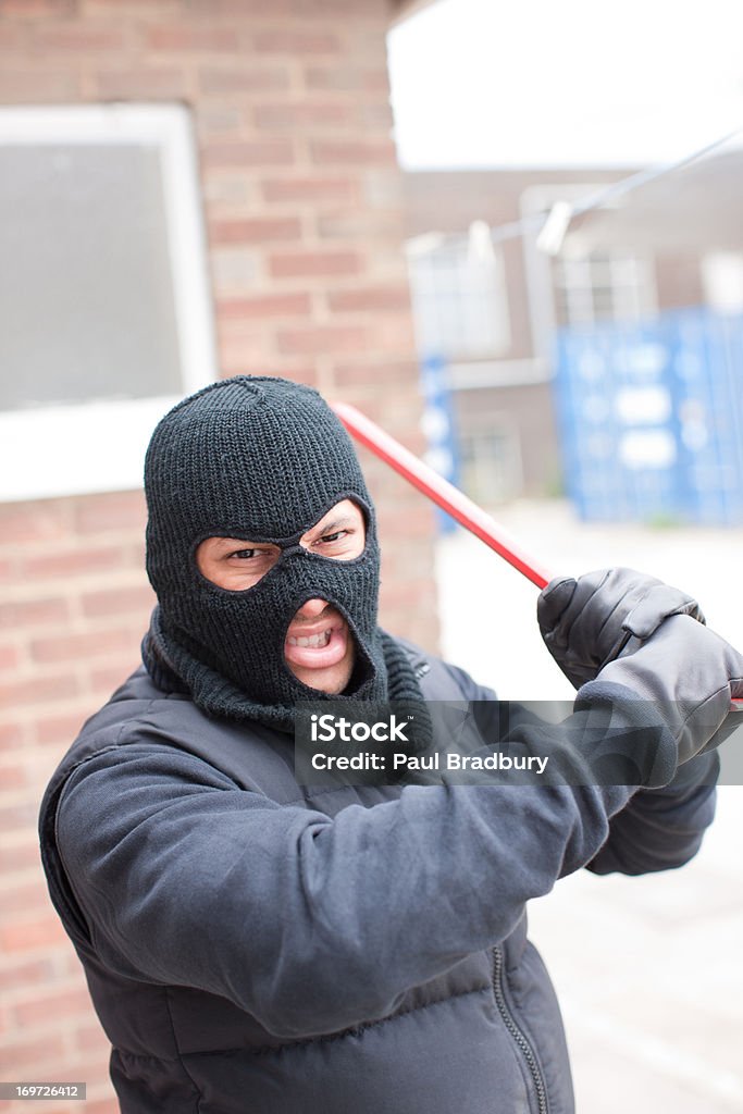 Burglar in ski mask wielding crowbar  25-29 Years Stock Photo