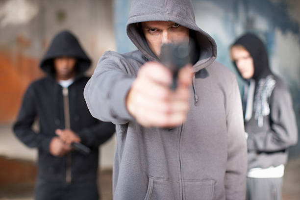 homem com arma apontada no visor - threats men african descent caucasian - fotografias e filmes do acervo