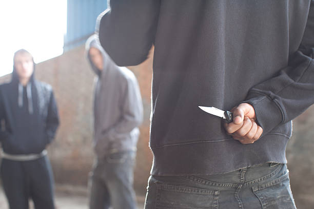 dos hombres que surja por el hombre con cuchilla - cuchillo arma fotografías e imágenes de stock