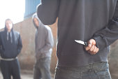 Two men being confronted by man with knife